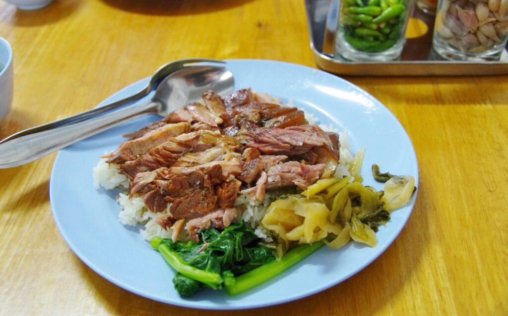 ノーンカイの市場で朝食に食べたタイ料理カオカームー(肉煮込みごはん)の写真。他にもカオマンガイもあり。