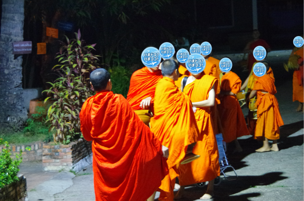 ラオスのルアンパバーンで、早朝の托鉢の準備で、寺院内で出口付近に集まってきた僧侶を比較的アップで撮った写真