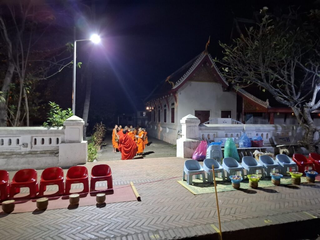 ラオスのルアンパバーンで、早朝の托鉢の準備で、寺院内で出口付近に集まってきた僧侶の写真