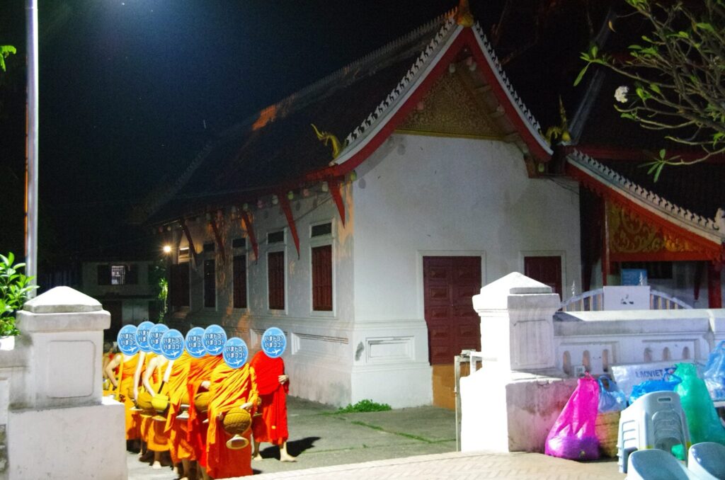 ラオスのルアンパバーンで、早朝の托鉢で、僧侶が寺院から出てきたときの写真