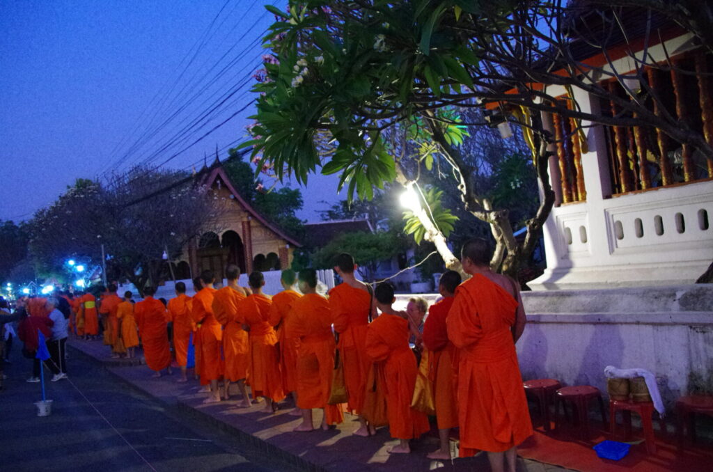 ラオスのルアンパバーンで、早朝の托鉢のときに大勢の僧侶が寺院から出てきたが、渋滞しているのを撮った写真