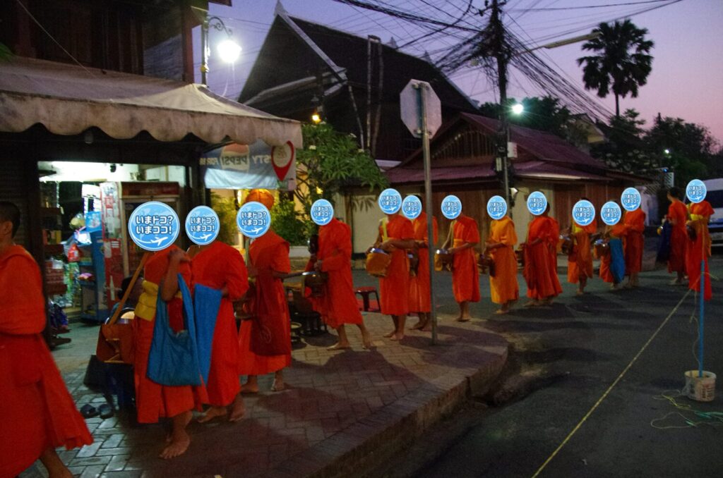 ラオスのルアンパバーンで、早朝の托鉢のときに大勢の僧侶が寺院から出てきたが、なかなか進めずに渋滞しているのを撮った写真