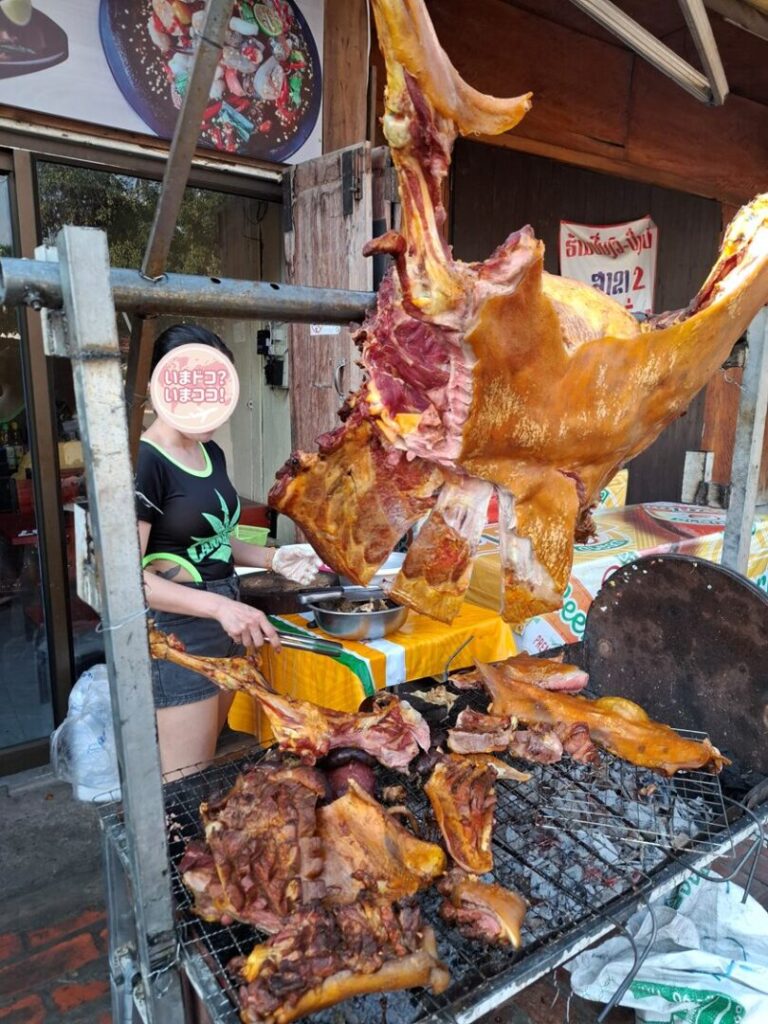 ルアンパバーンで、豚の丸焼きを料理している店で撮った豚の丸焼きを焼いている写真