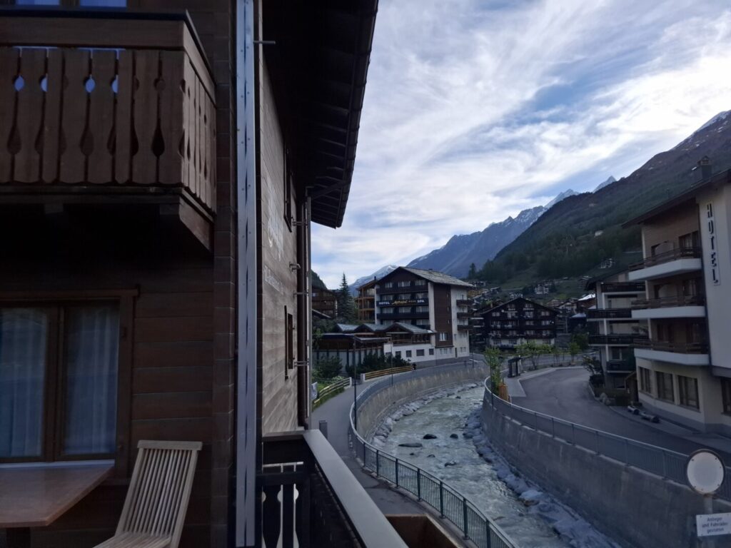 スイスのツェルマットで筆者が宿泊したコスパ抜群のホテルMazot Zermattで、宿泊した部屋のテラスを横に流れている小川と一緒に撮った写真