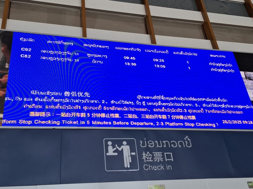 管理人が撮影したラオス中国鉄道(LCR)のビエンチャン駅の電光掲示板の写真。僧侶郵船の文字が見える。