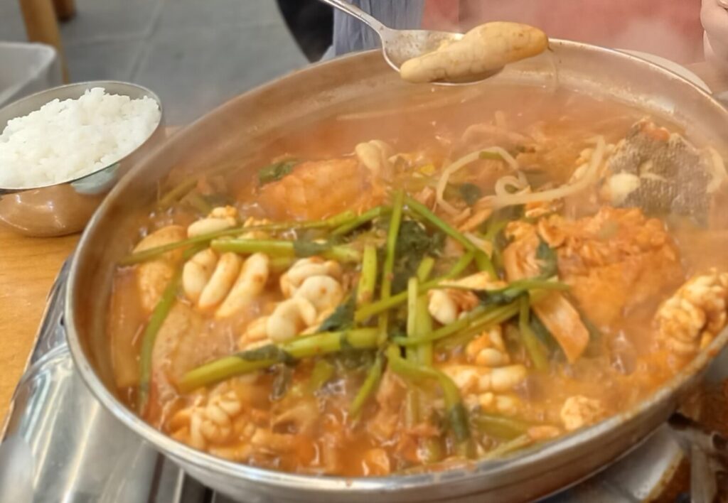 筆者が訪れたソウルの広蔵市場内にあるウンソンメウンタンでメウンタンを食べた際にタラコを持ち上げている写真