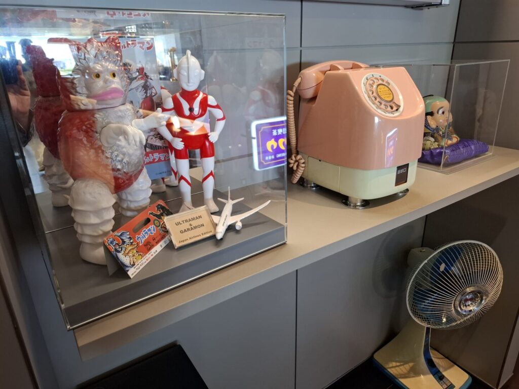 筆者が訪れた成田空港の第2ターミナルのラウンジKocoo内にある古い公衆電話とウルトラマンのソフビ人形の写真