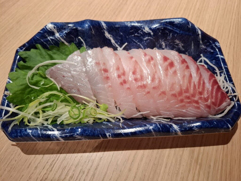 筆者が宿泊したカンデオホテルズ福山でハッピーアワーで食べた尾道産の天然真鯛の刺身を撮った写真