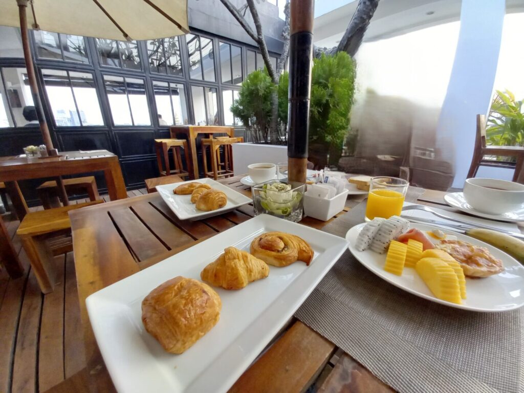 筆者がプノンペンで宿泊したPatio Hotel & Urban Resortの朝食のビュッフェ会場で多くの種類のパンとフルーツを撮った写真