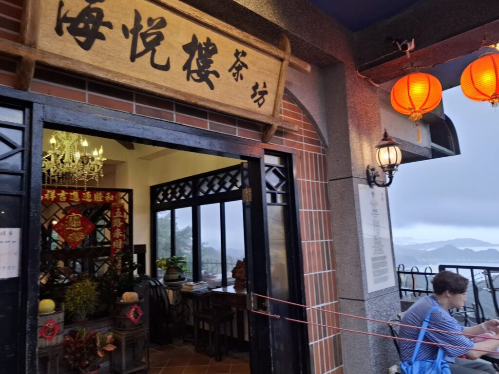 筆者が訪れた九份の海悦楼茶坊で、入口の看板と眼下にひろがる海の景色を撮った写真