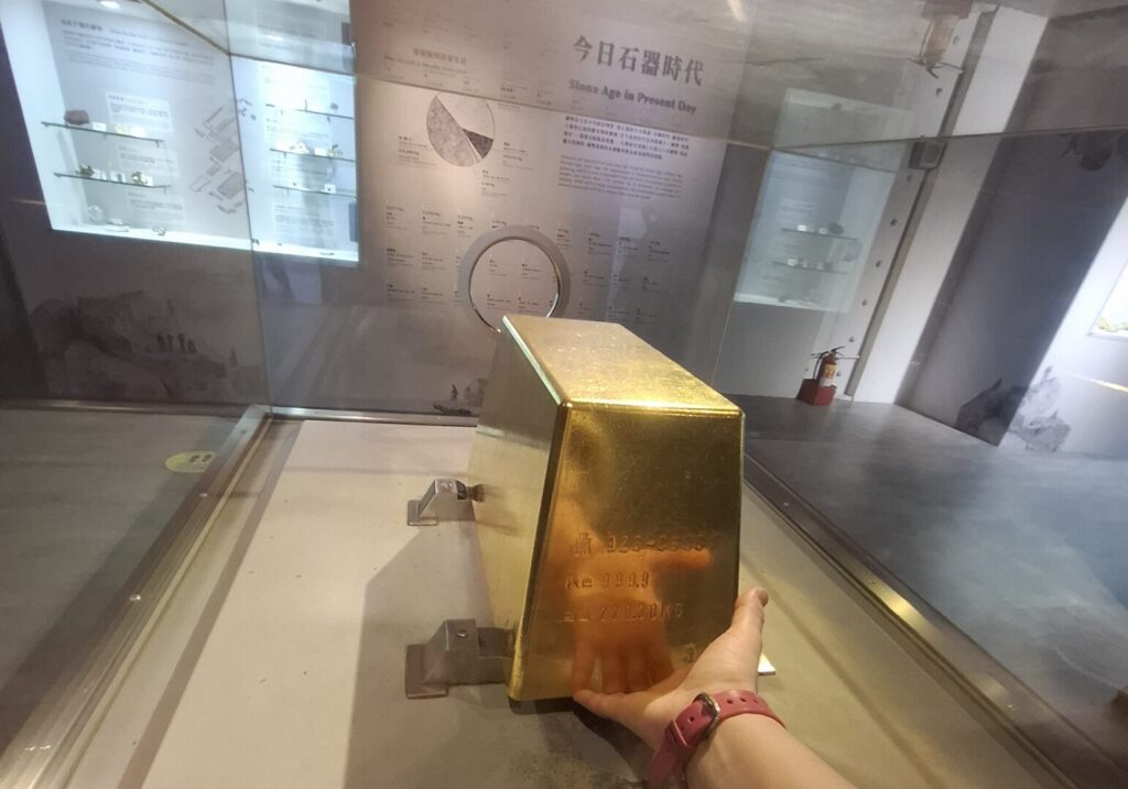 筆者が訪れた金瓜石の黄金博物館で、実際に触ることができる金塊を、手を入れる穴から触っているのを撮った写真