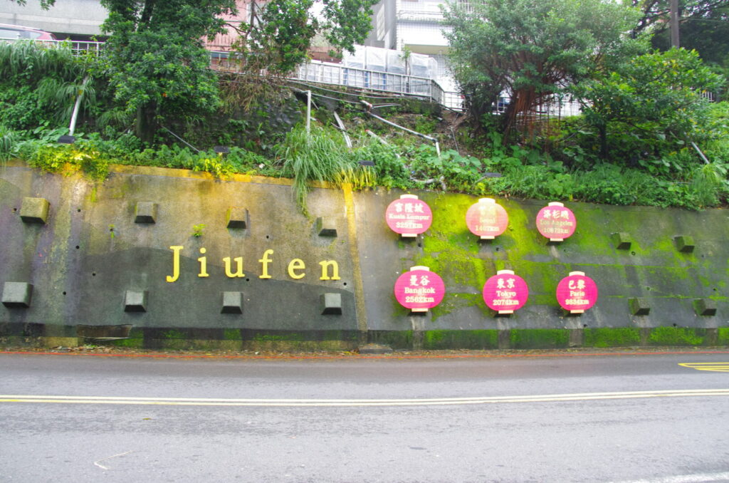 筆者が金瓜石から訪れた九份で、バス停の前に掲示されていた世界各都市までの距離数を表示した看板を撮った写真