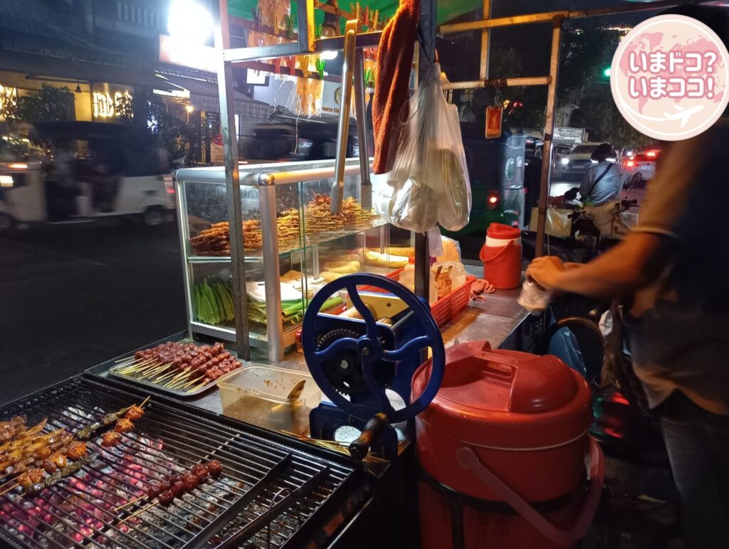 筆者がプノンペンで宿泊したPatio Hotel & Urban Resortのすぐ近くの屋台で串焼きを買っている様子を撮った写真