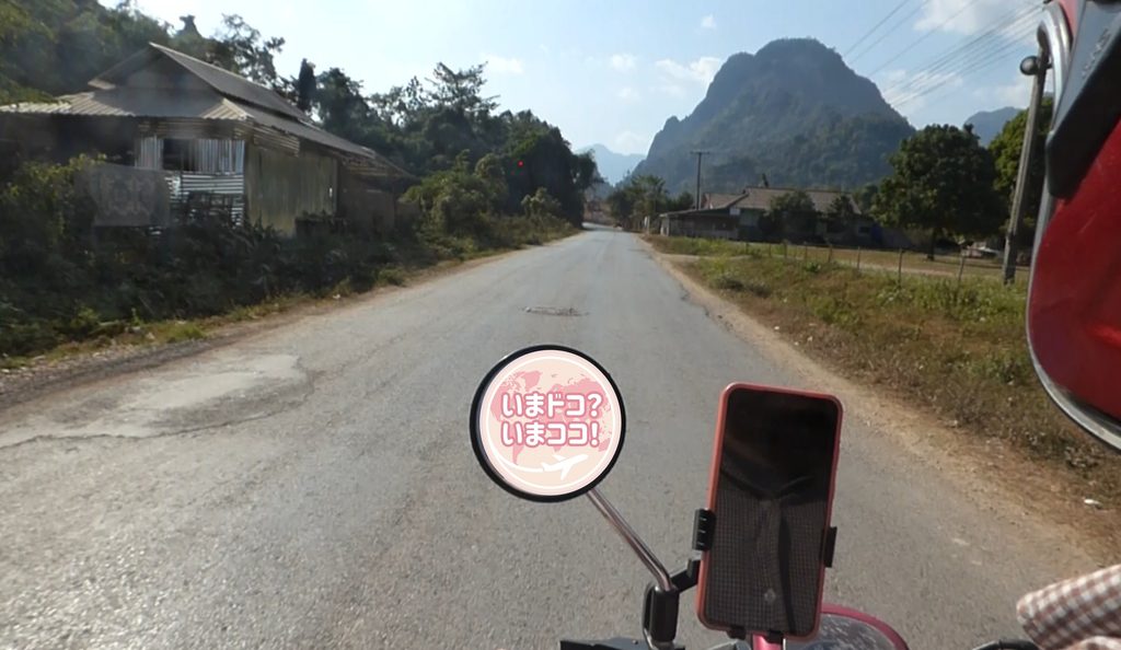 筆者がレンタルバイクでバンビエンのブルーラグーンに向かって山々を見ながら走っている様子を撮った写真