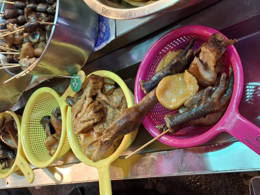 筆者が台湾の臨江街夜市で訪れた梁記滷味で料金表を一緒にとった写真