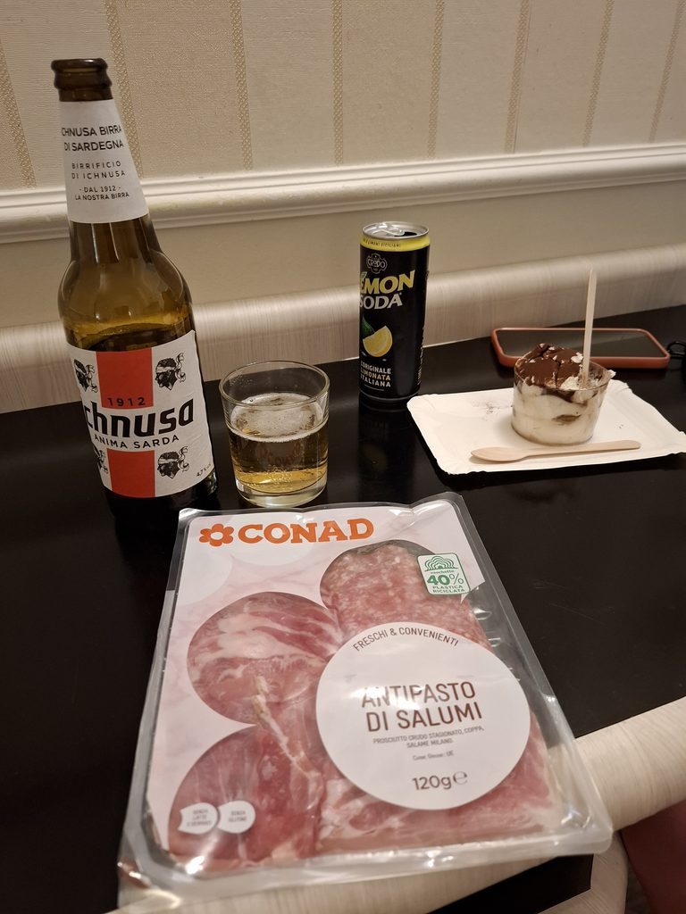 筆者が宿泊したホテルフローラで、部屋で生ハムとビール、デザートを撮った写真