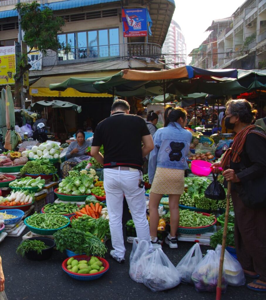 筆者が訪れたプノンペンのオルセーマーケットの外の路上で地元の人が野菜を買っている様子を撮った写真
