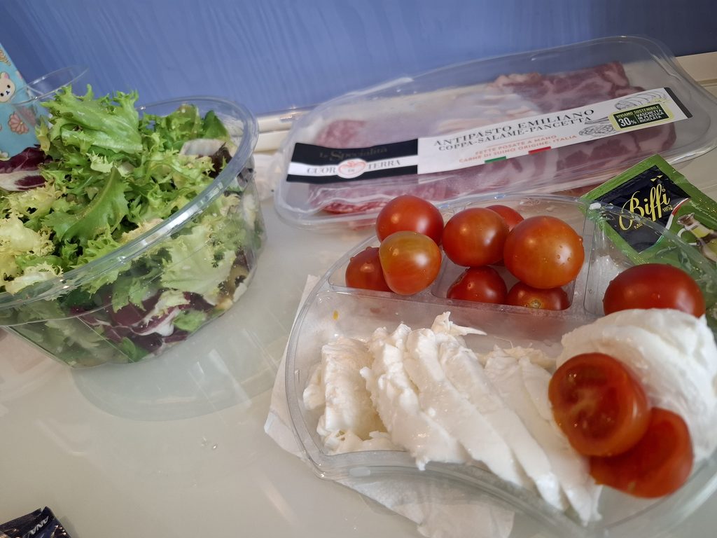 筆者が宿泊したホテルグラムミラノで、スーパーで買ったサラダと生ハムを朝食としていただく様子を撮った写真
