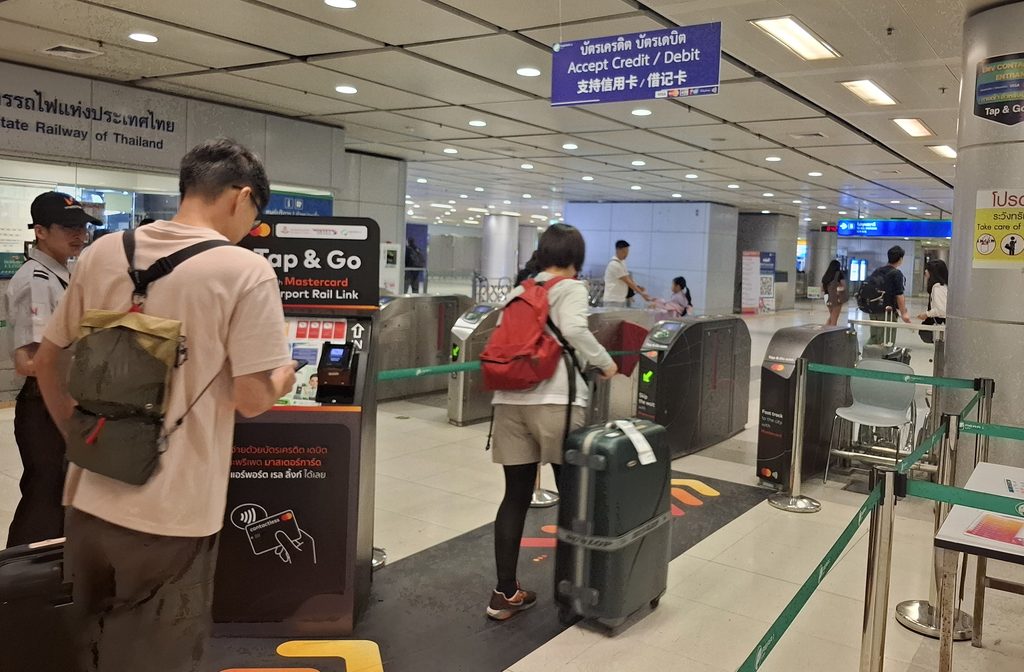 筆者がタイで訪れたエアポートレイルリンクのスワンナプーム空港駅でクレジットカードのタッチ決済を利用して改札を通る観光客の写真