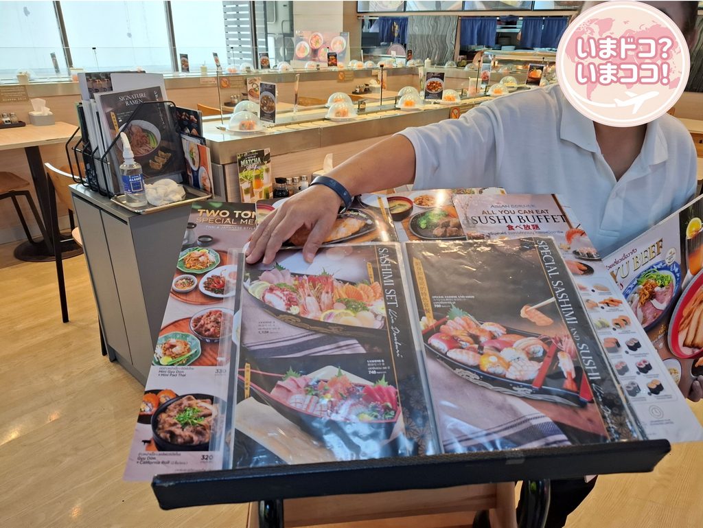 筆者が訪れたドンムアン空港にある回転ずし店でメニューの説明をしてくれている写真