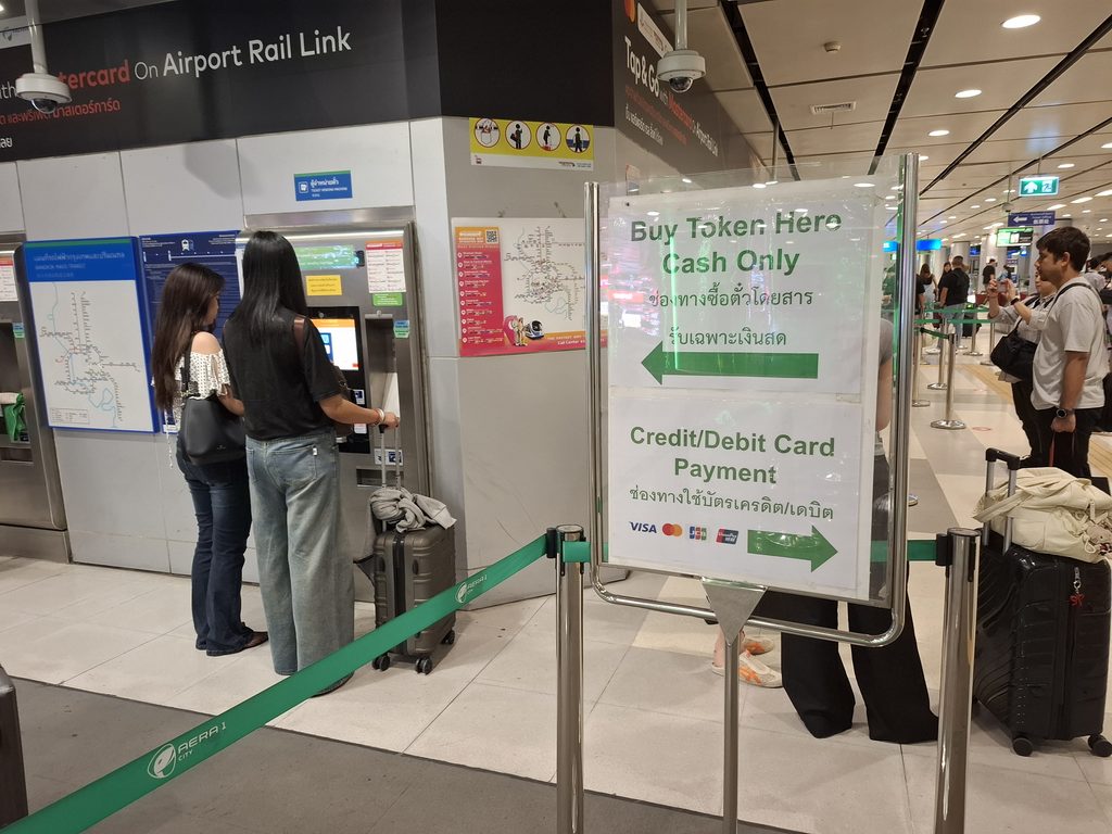 筆者がタイで訪れたエアポートレイルリンクのスワンナプーム空港駅でトークンを買う側とクレジットカードのタッチ決済側に分かれていることを掲示した案内の写真